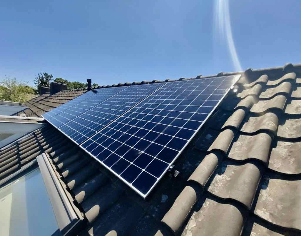 Zonnepanelen op een schuin dak met blauwe lucht in mei 2025